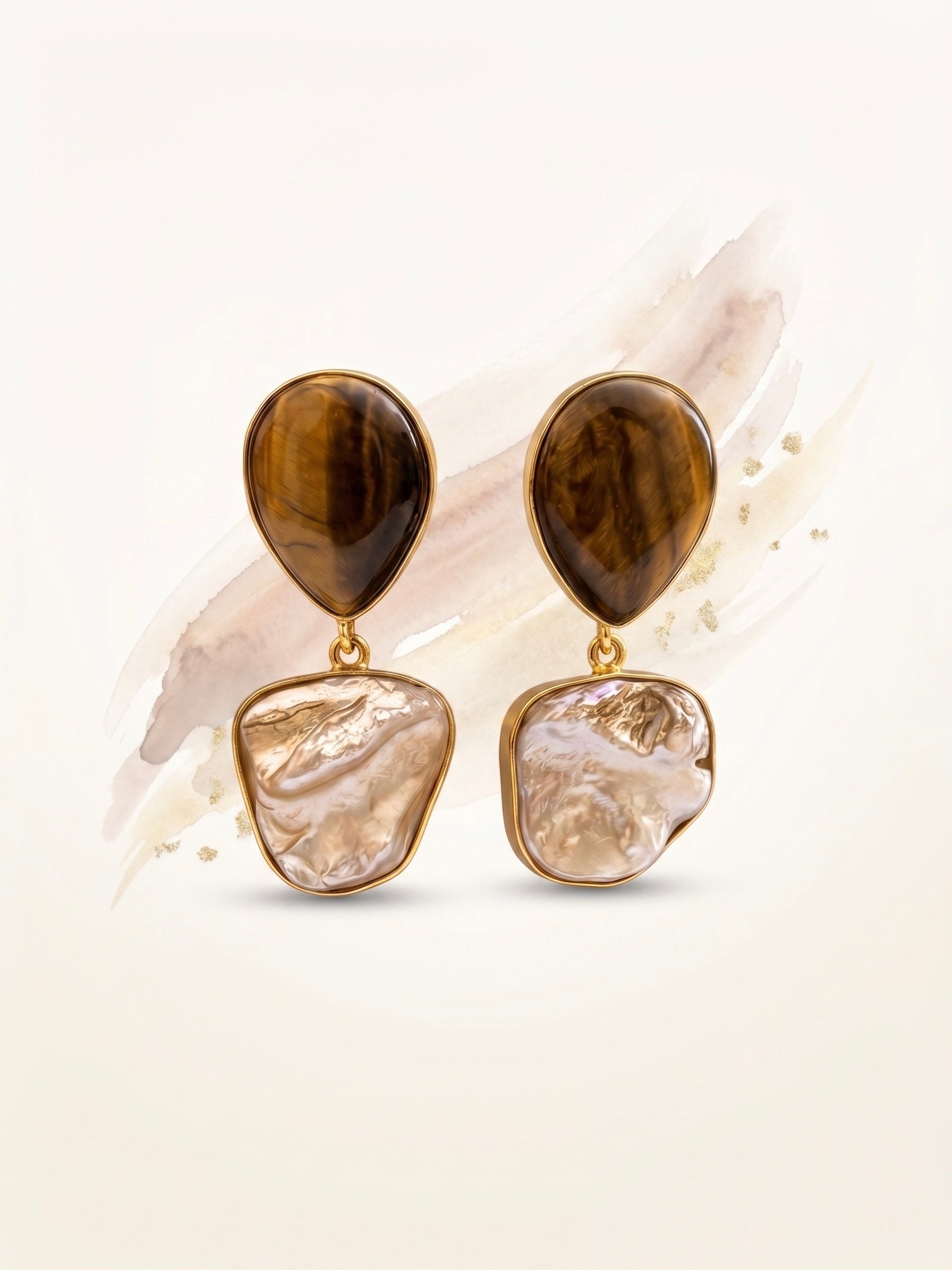 Pair of earrings with brown and beige stones on a light background